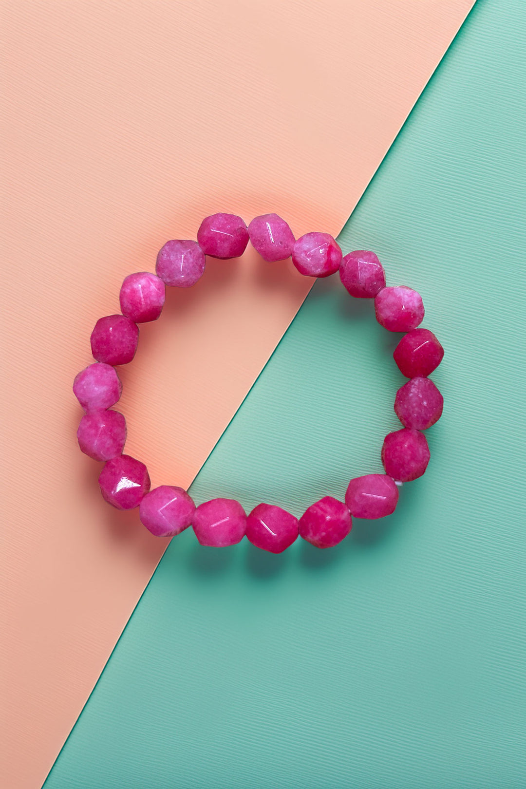 Top view of a pink beaded bracelet on pastel background