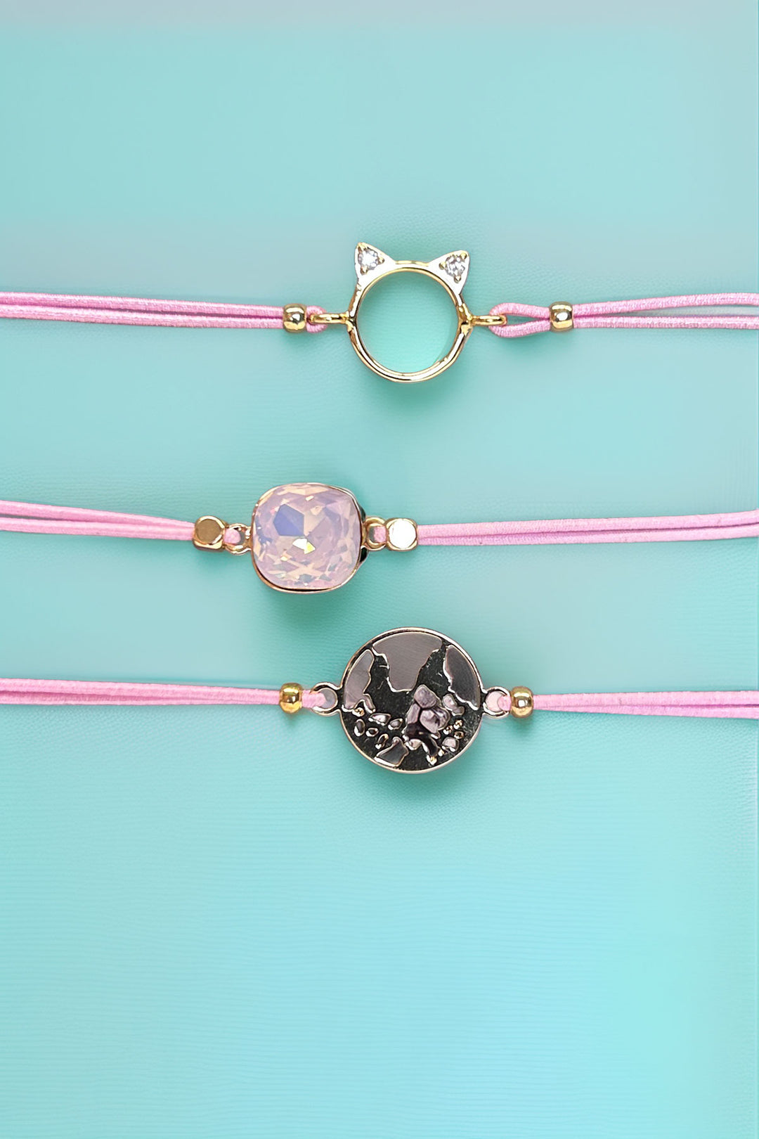 Three unique pink bracelets with gold accents on display