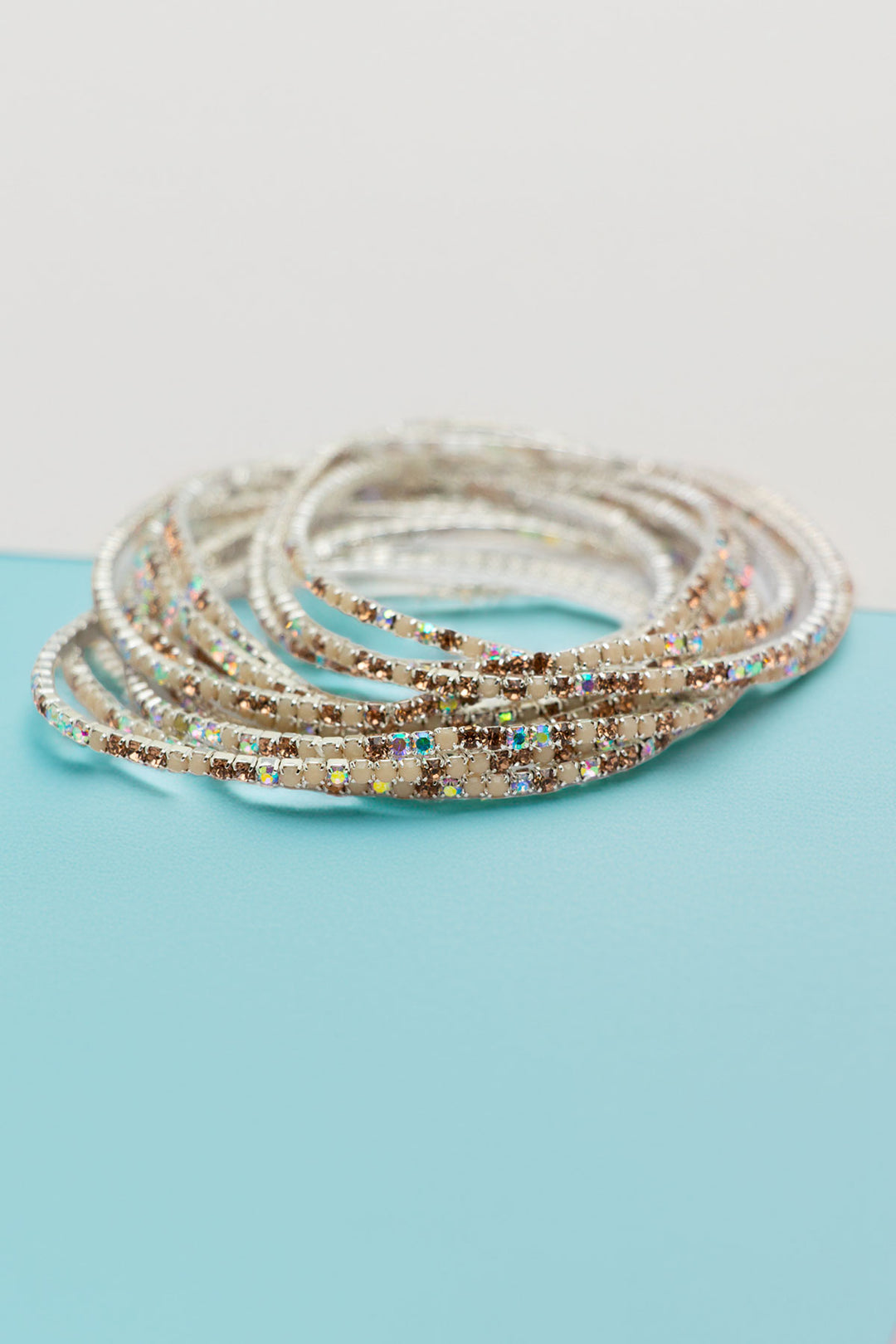 Rhinestone bangle set of 12 pieces on a turquoise surface