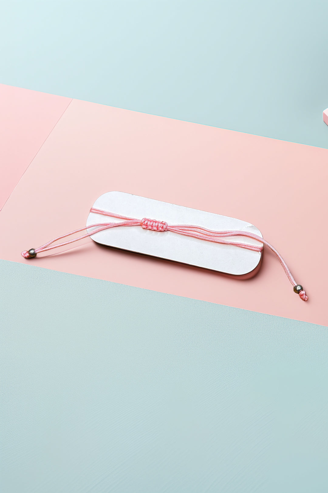 Flat view of pink adjustable bracelet on pastel background