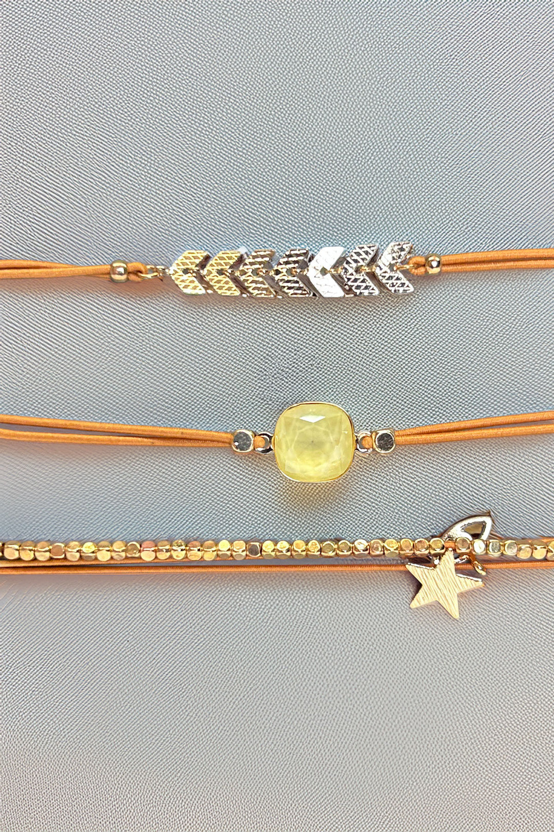 Front view of gold-tone triple bracelet set with star charm