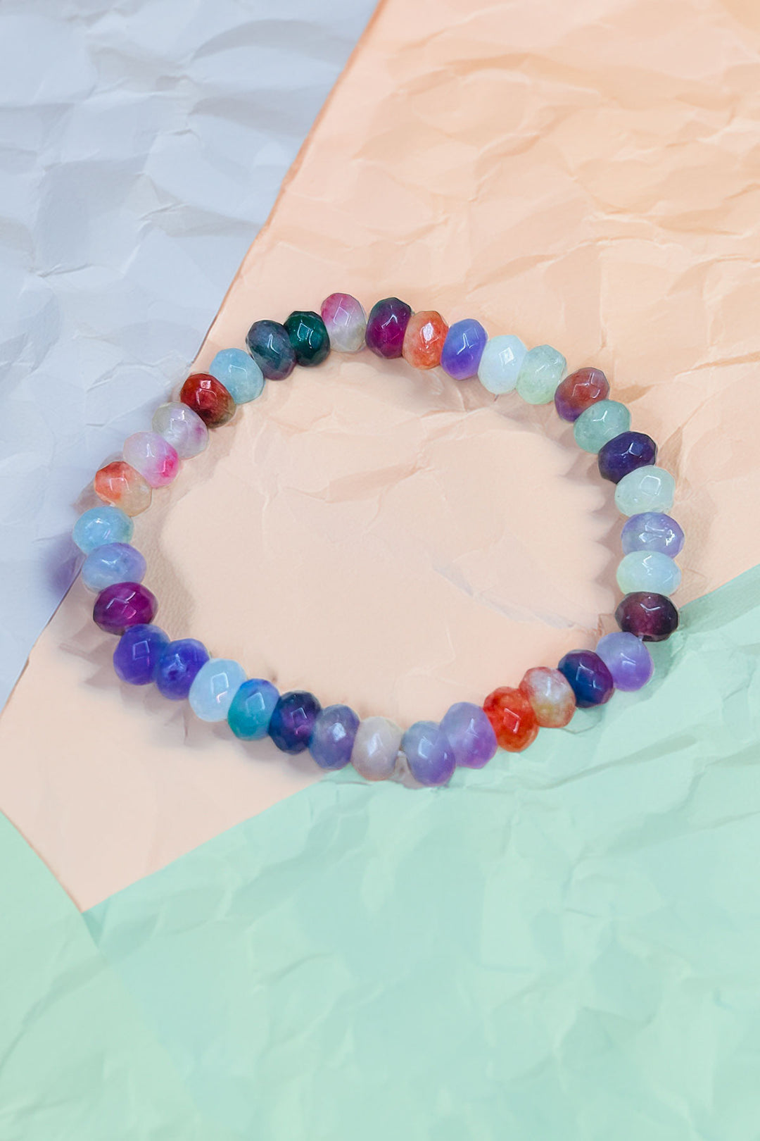Vibrant multicolor beaded bracelet on pastel background
