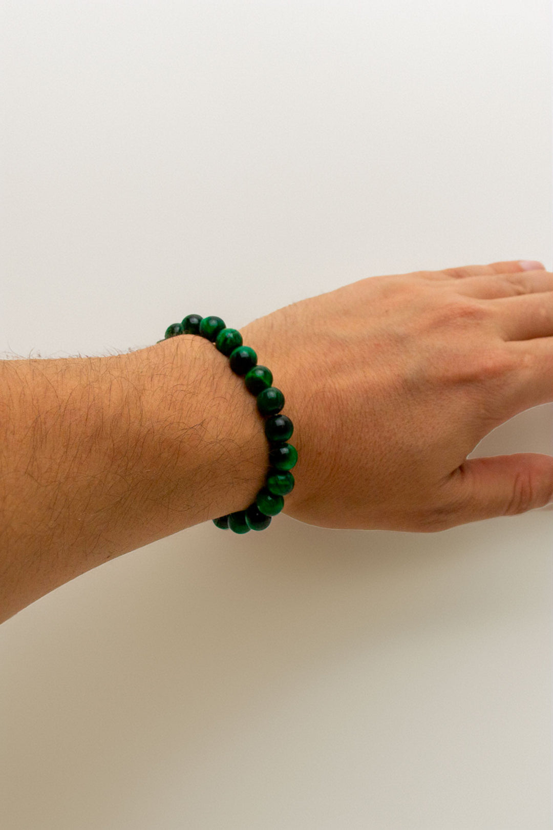 Green beaded bracelet worn on a wrist to show fit