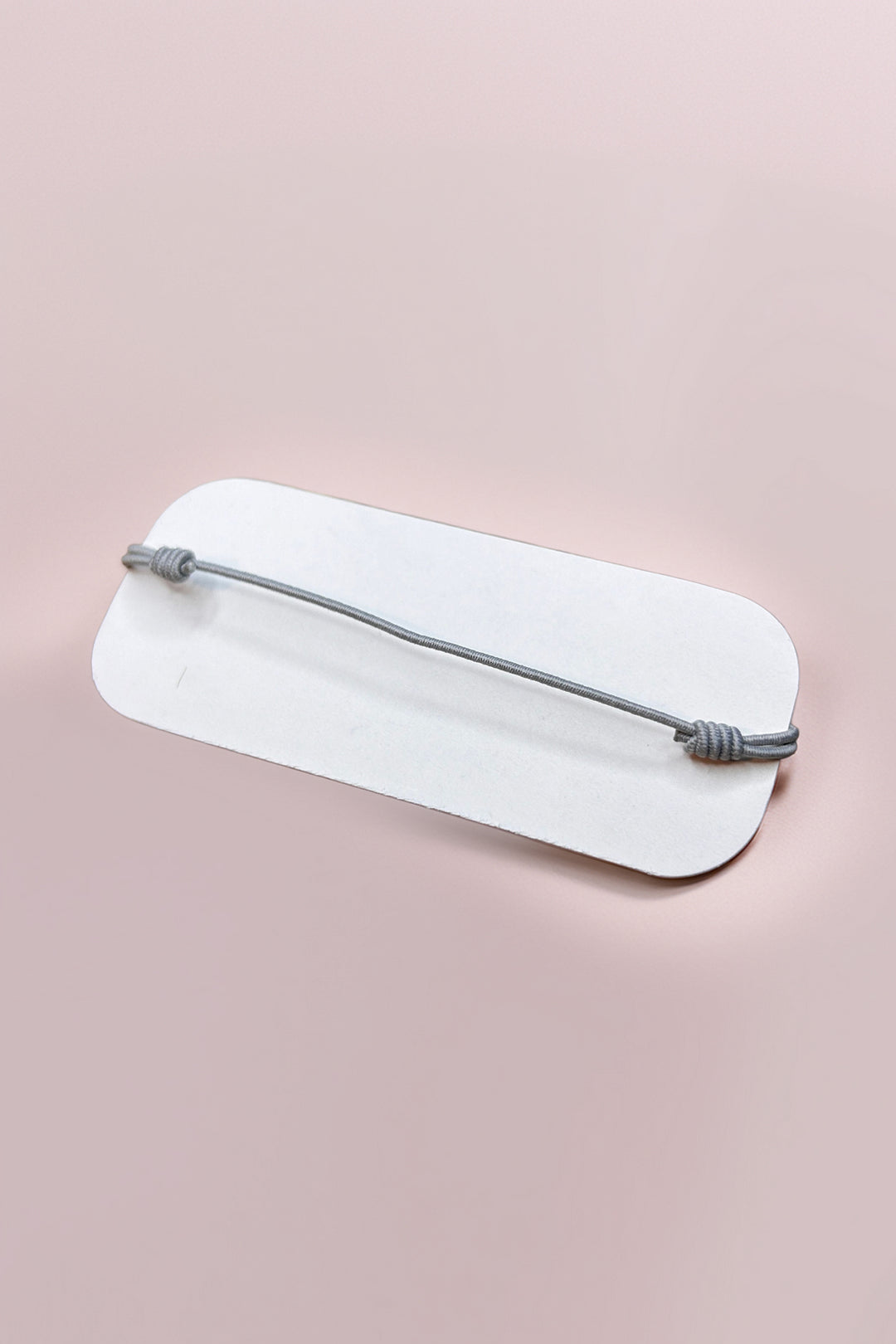 Back view of adjustable rose quartz bracelet on display card
