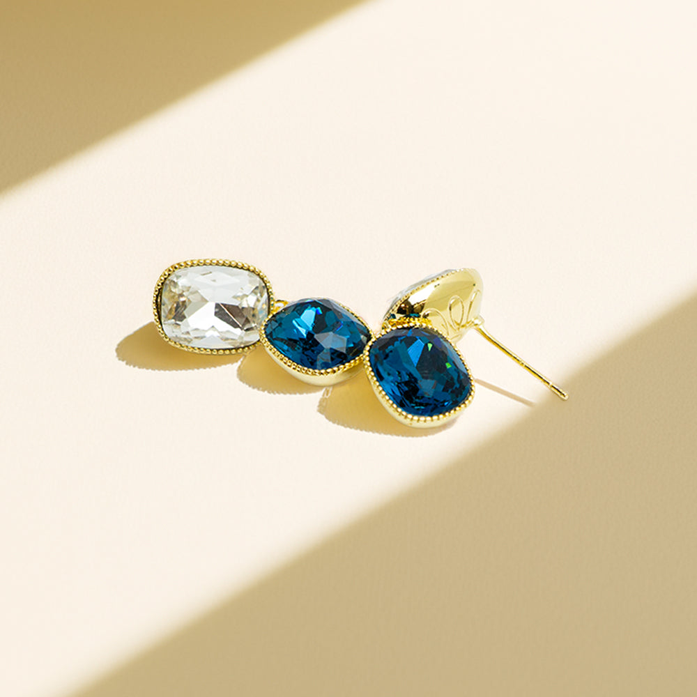 Side view of blue and clear crystal earrings in sunlight