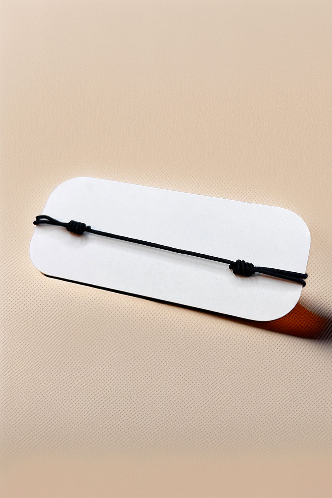 Back view of the bracelet on a card showing adjustable strap