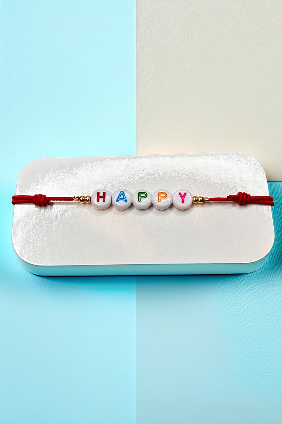 Front view of the 'Happy' bracelet with red cord