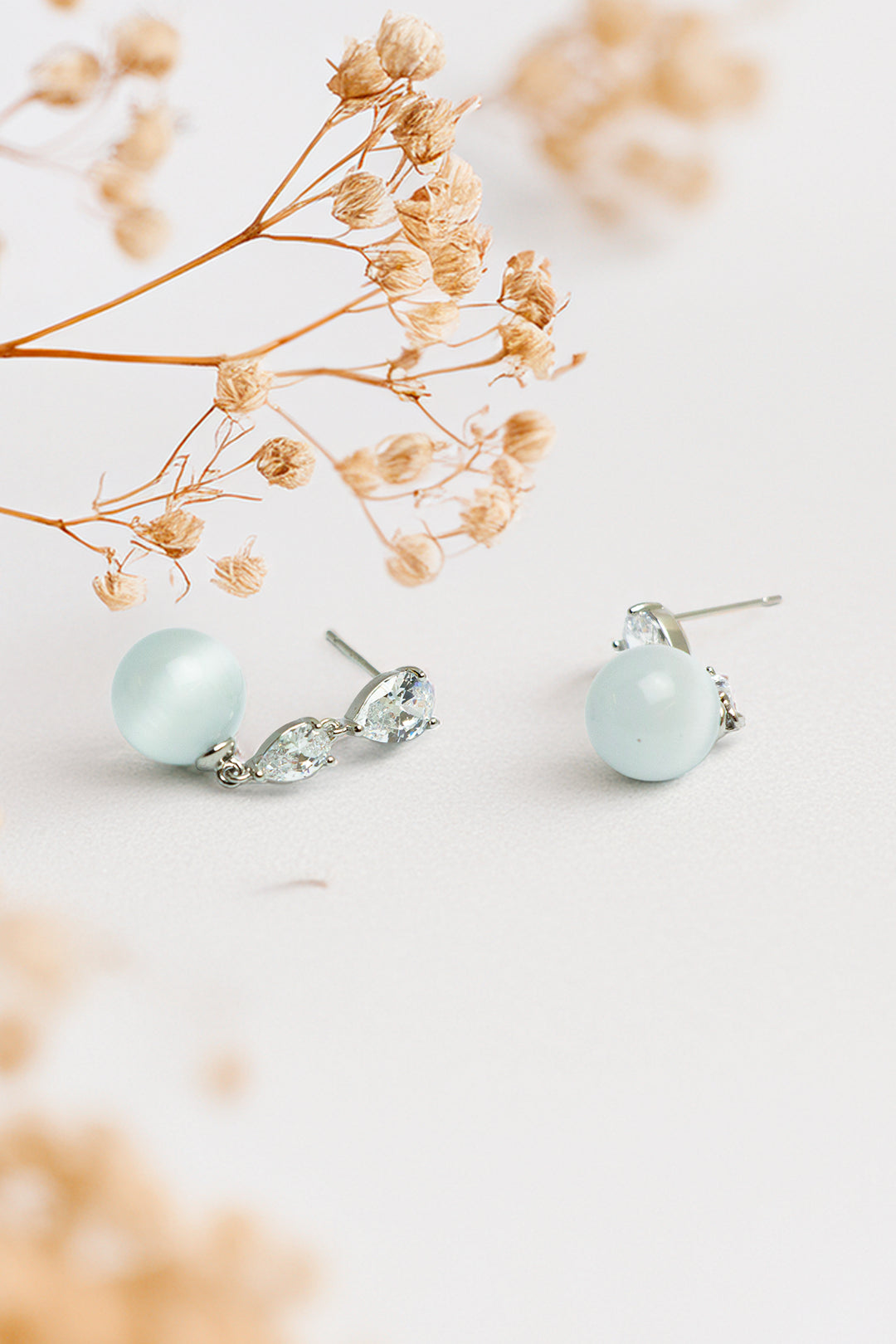 Earrings on display with floral decoration in the background
