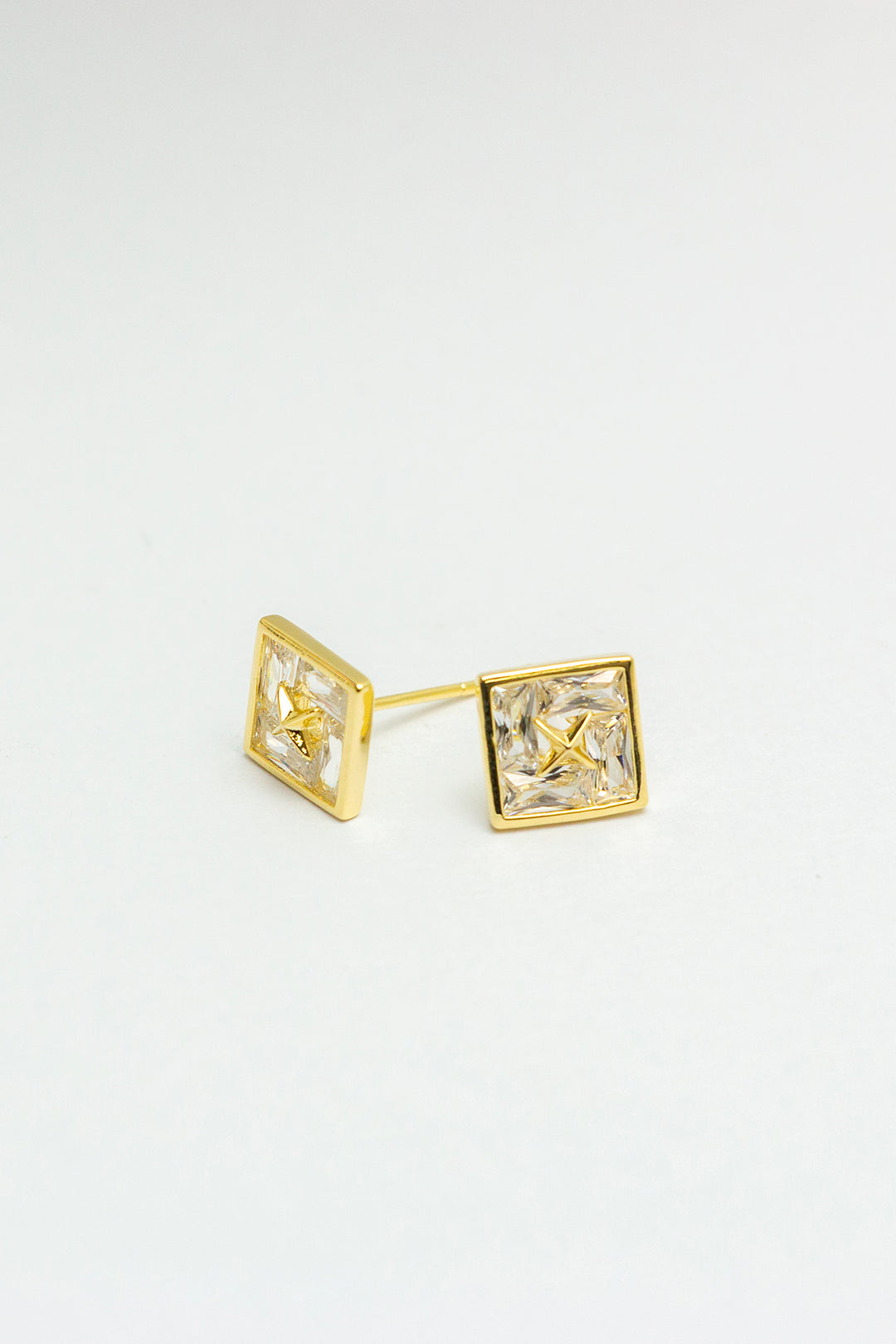 Gold-tone stud earrings on white background