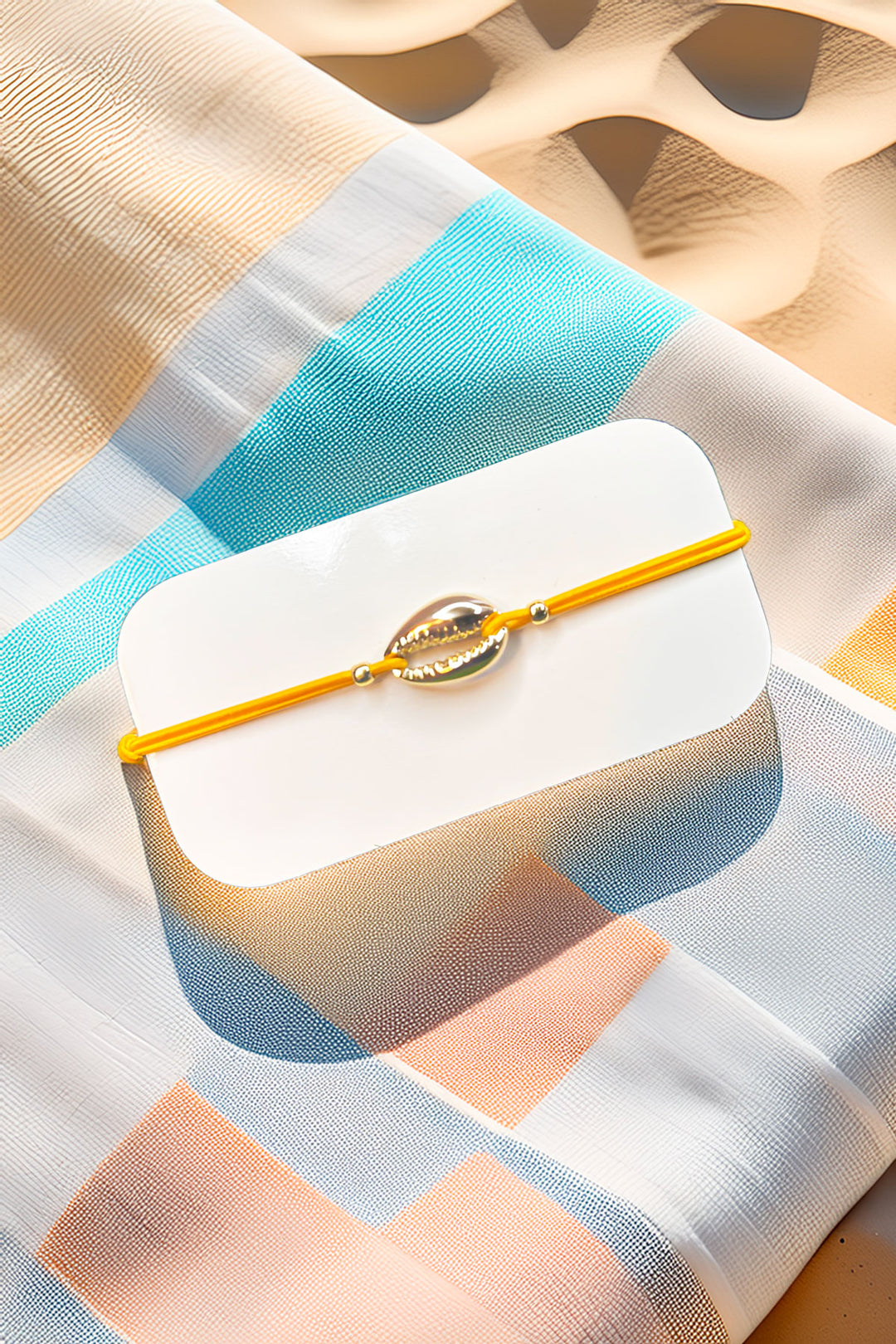 Cowrie shell bracelet displayed on a textured fabric