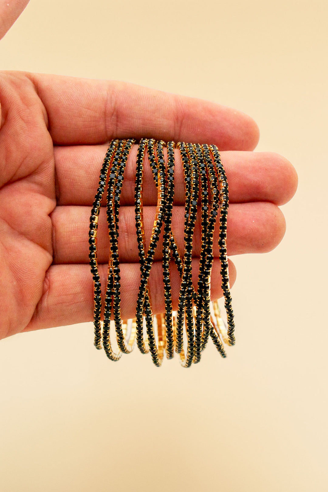 Hand holding multiple rhinestone bracelets