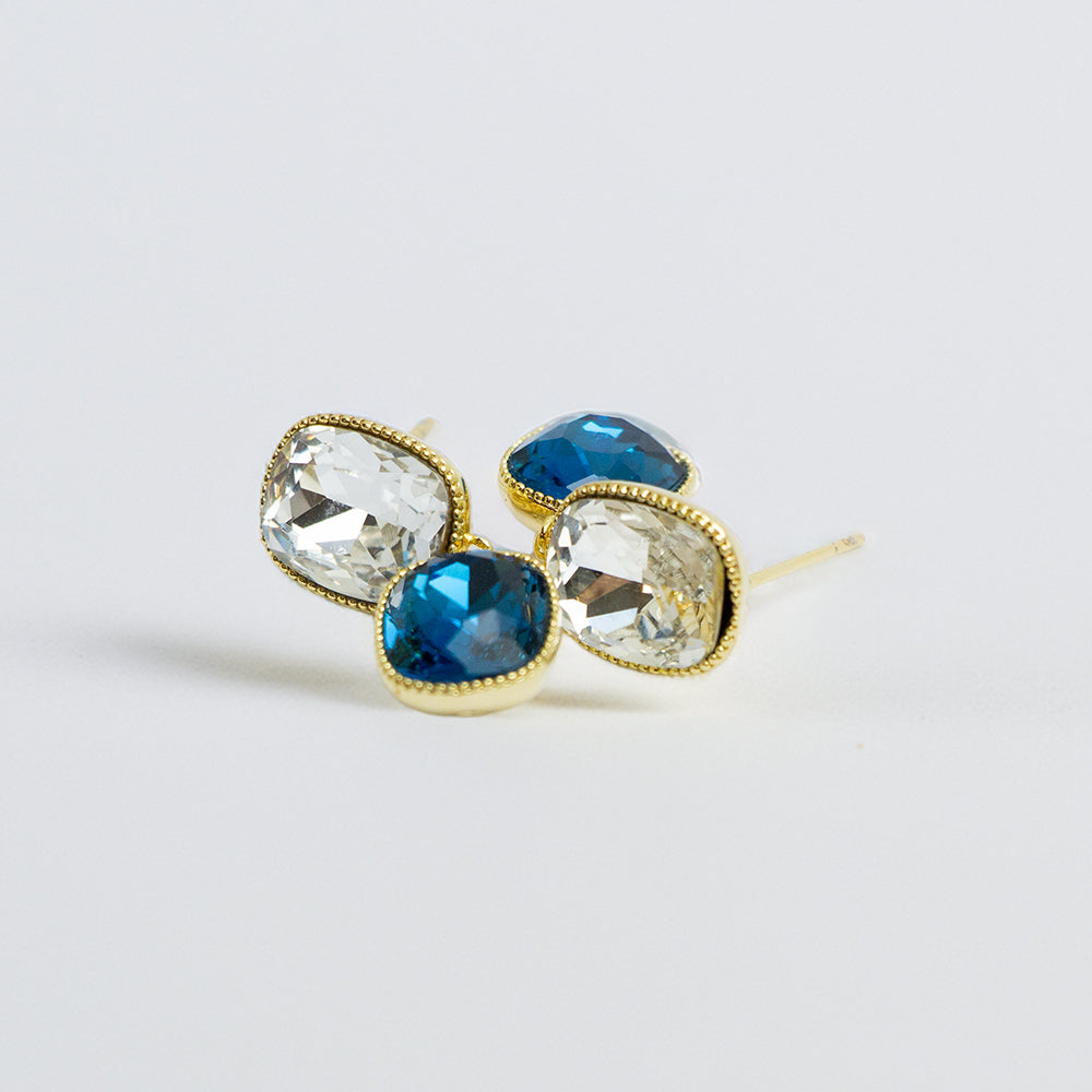 Blue and clear crystal earrings on a white surface