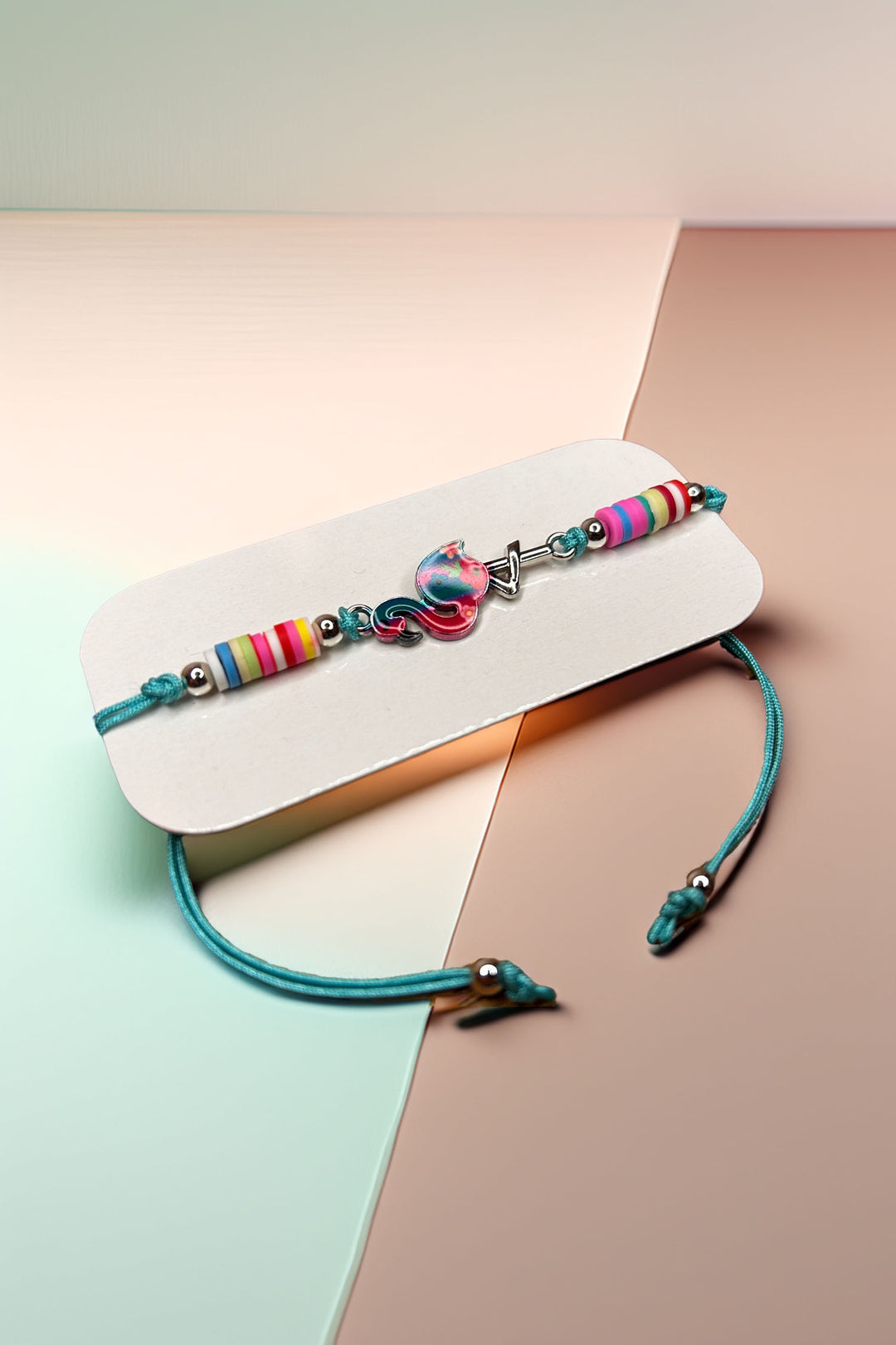 Angled side view of multicolored bracelet with charm