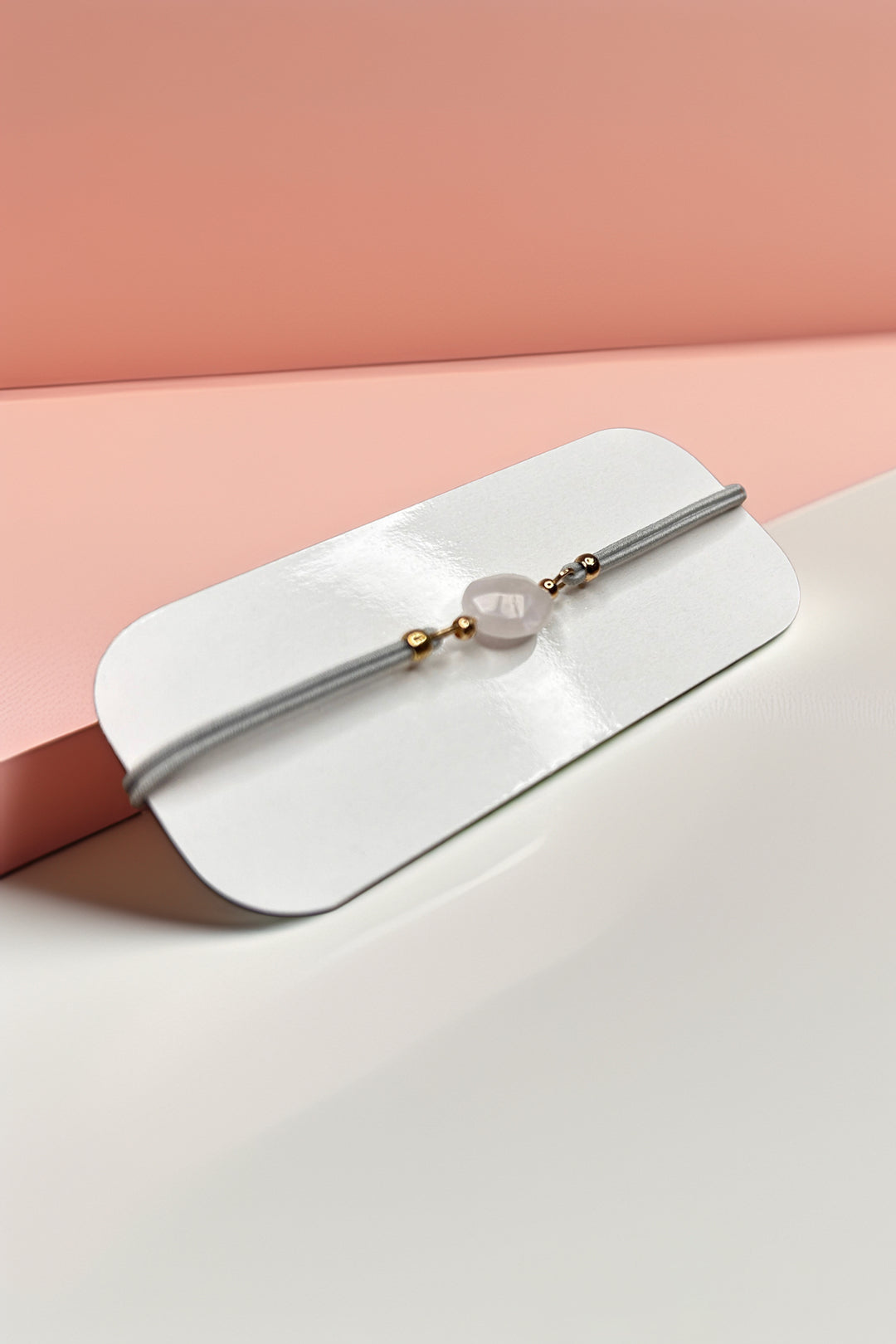 Side angle of rose quartz bracelet with gold accents