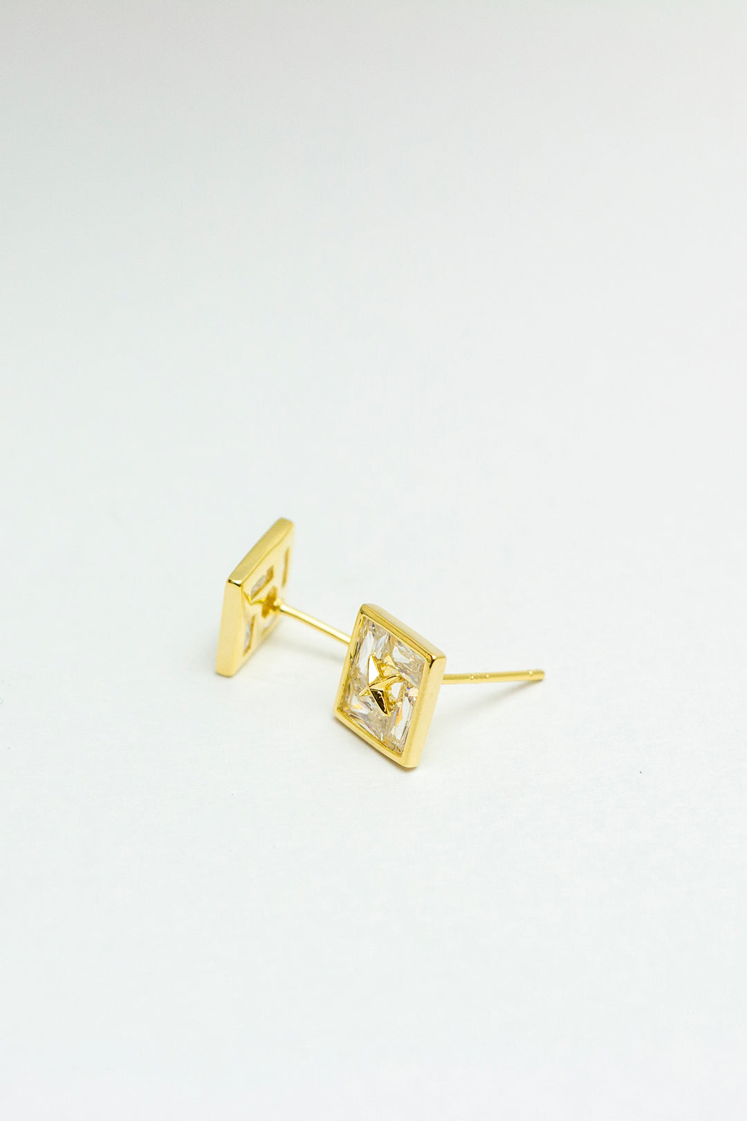 Side angle of gold-tone stud earrings