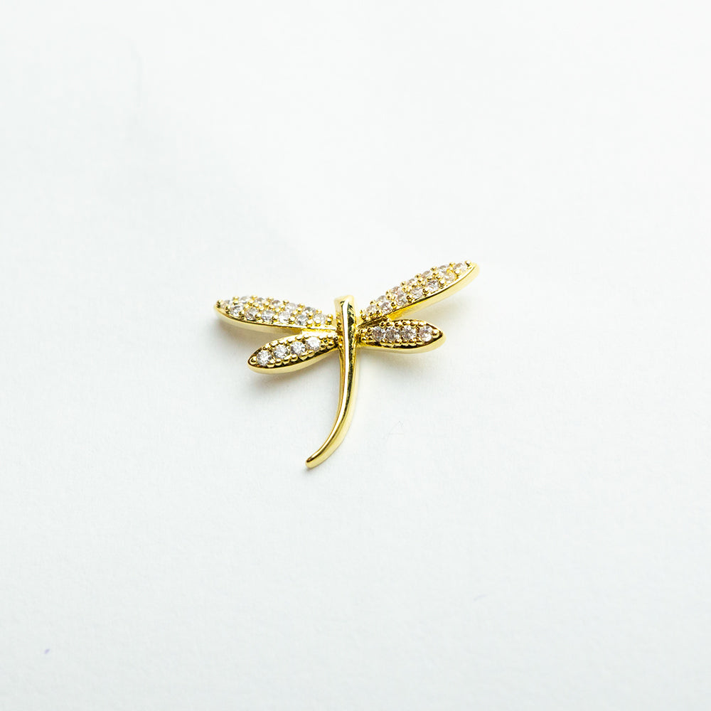 Single gold dragonfly earring on white background