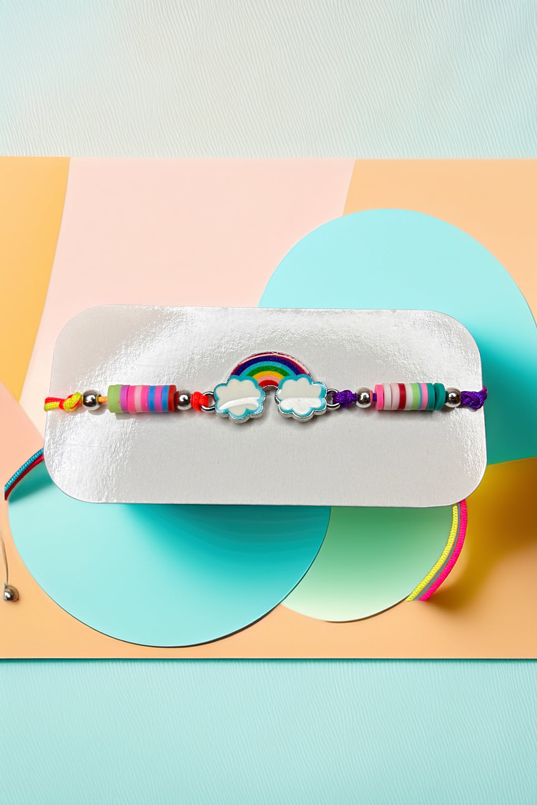 Close-up of rainbow charm and beads on bracelet