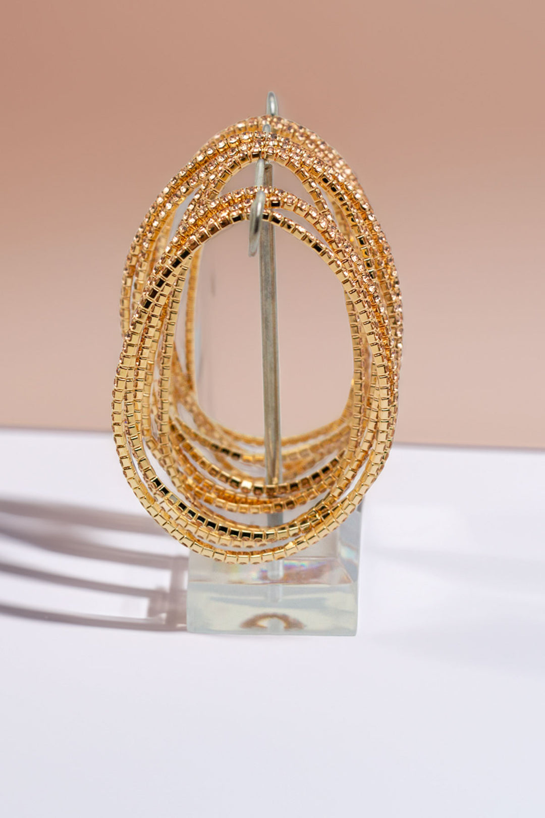 Front view of rhinestone bangles set on a clear stand