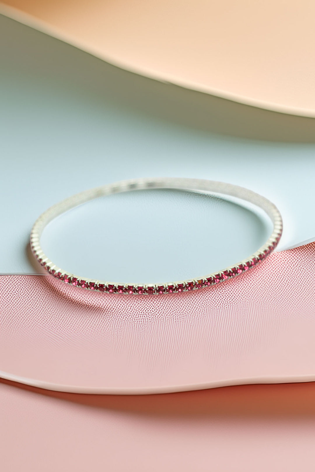 Single rhinestone bracelet on textured background