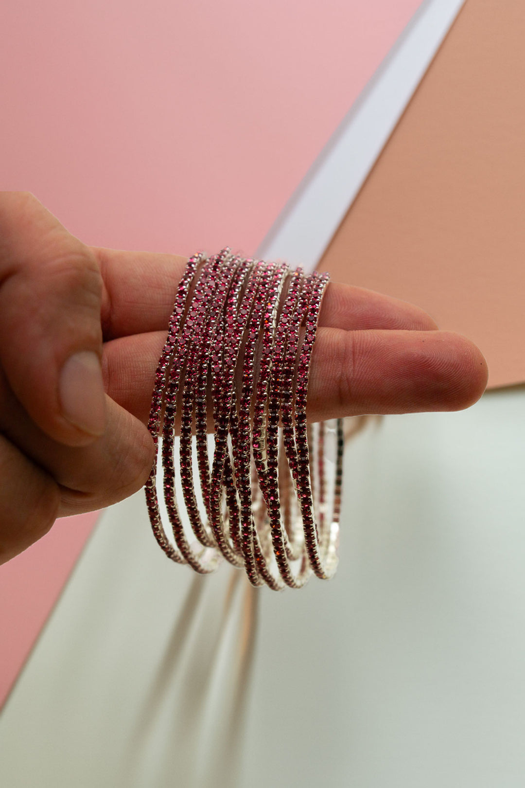 Hand holding the full stack of rhinestone bangles