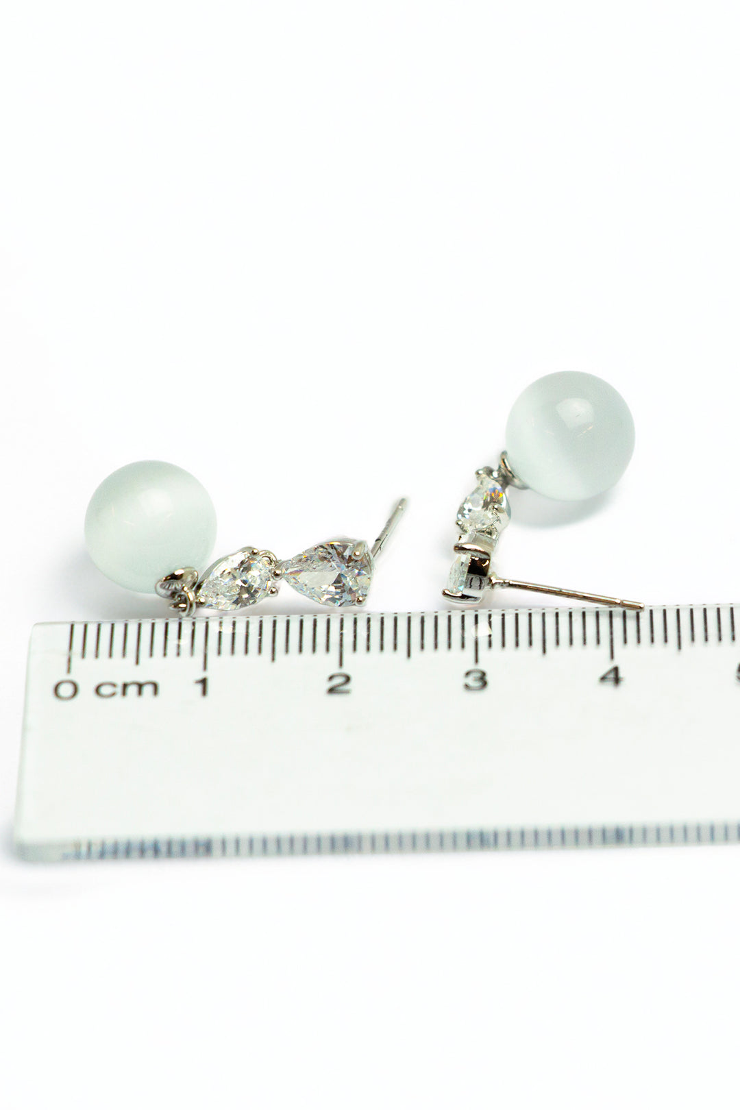 Pearl and crystal earrings with measurement scale