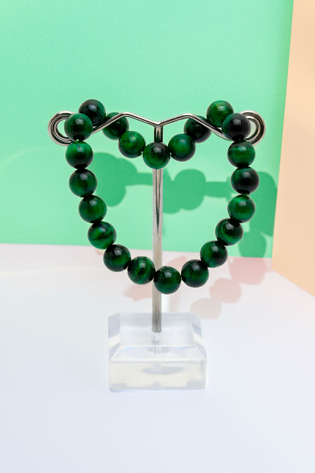 Elegant green beaded bracelet on a display stand