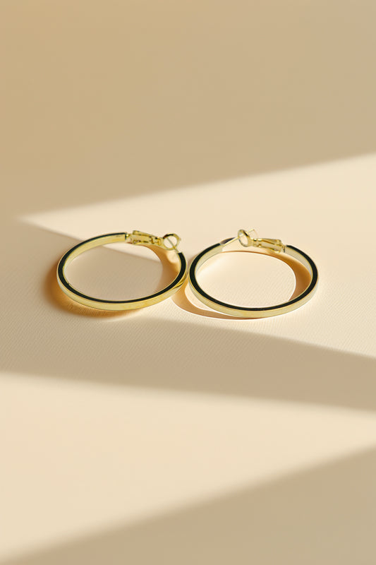 Pair of gold hoop earrings on a beige background