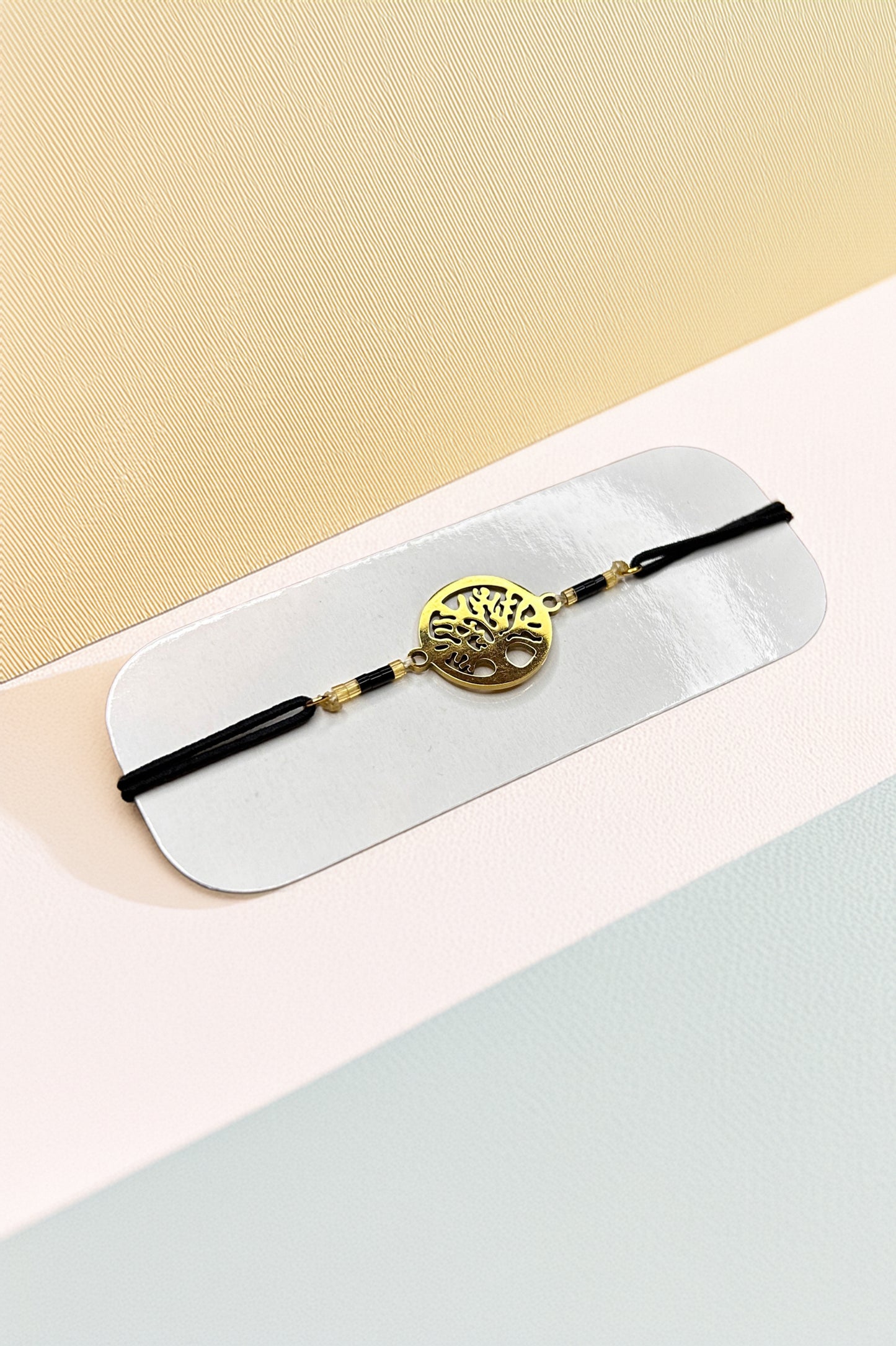 Tree of Life bracelet with gold-tone charm on black cord background