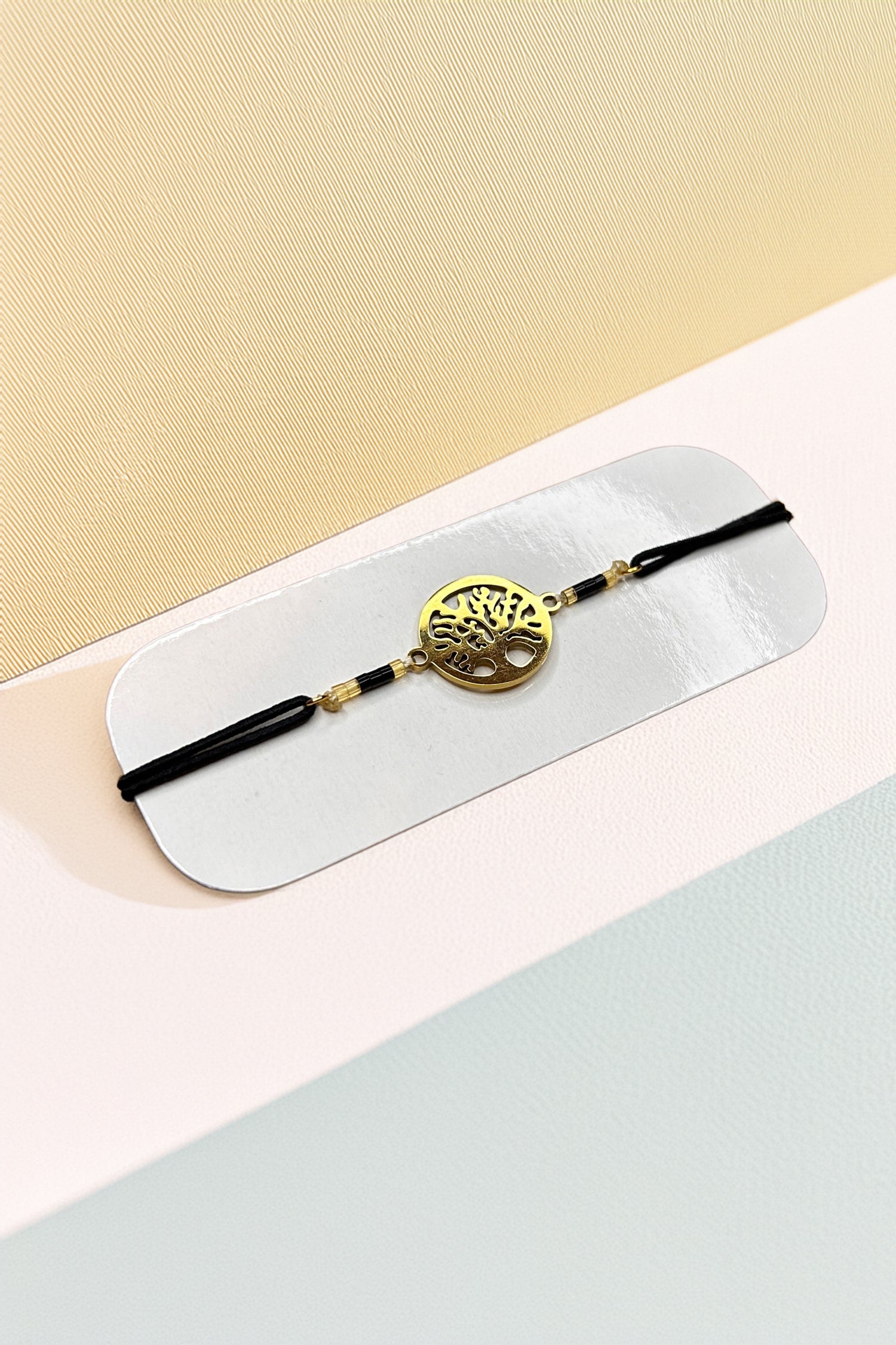 Tree of Life bracelet with gold-tone charm on black cord background
