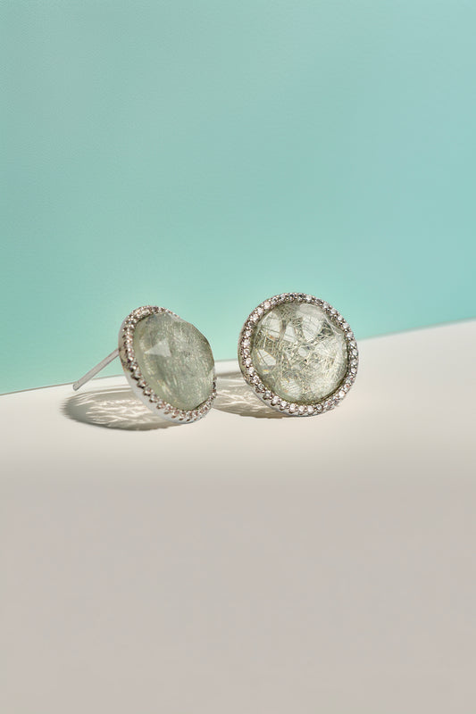 Quartz stud earrings on turquoise background