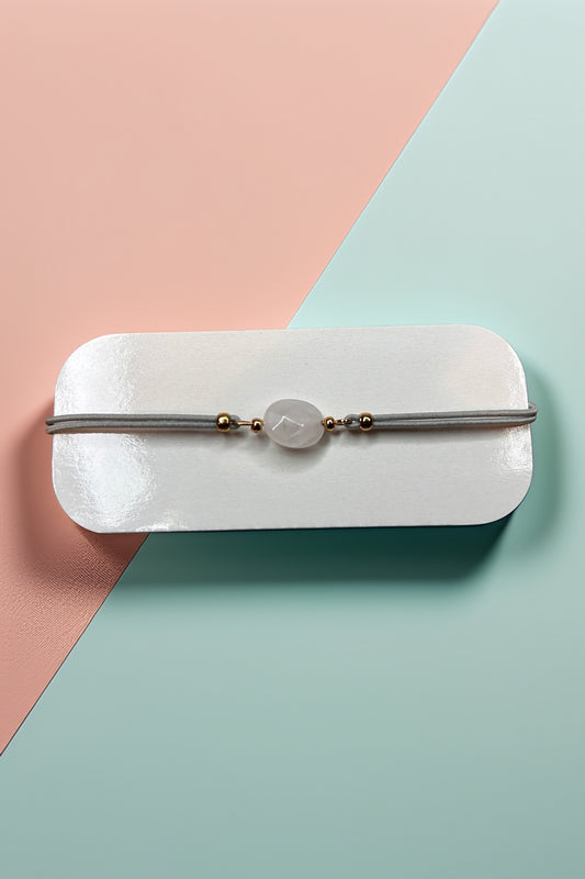 Elegant rose quartz bracelet with gold bead accents on display card