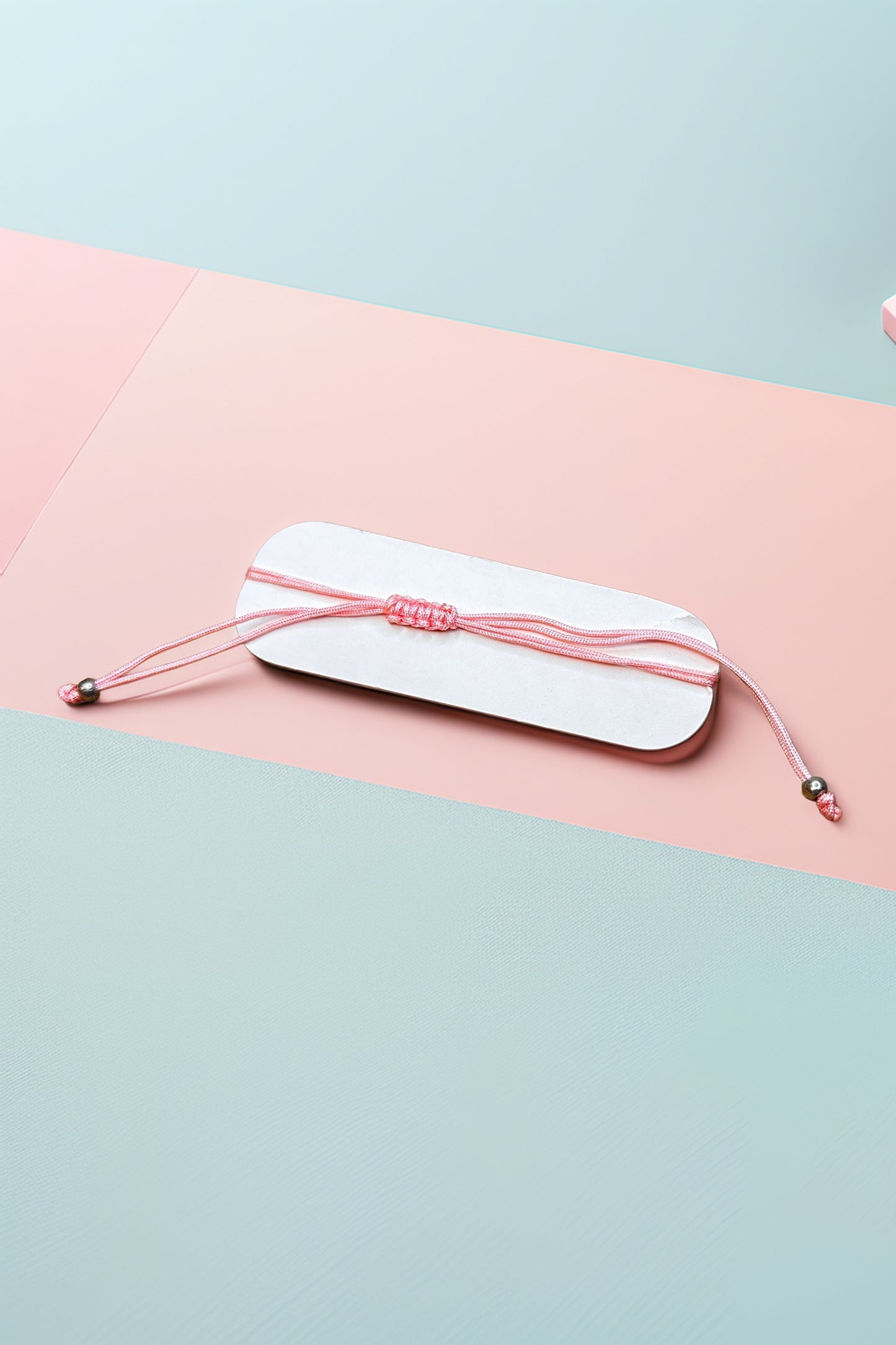 Flat view of pink adjustable bracelet on pastel background
