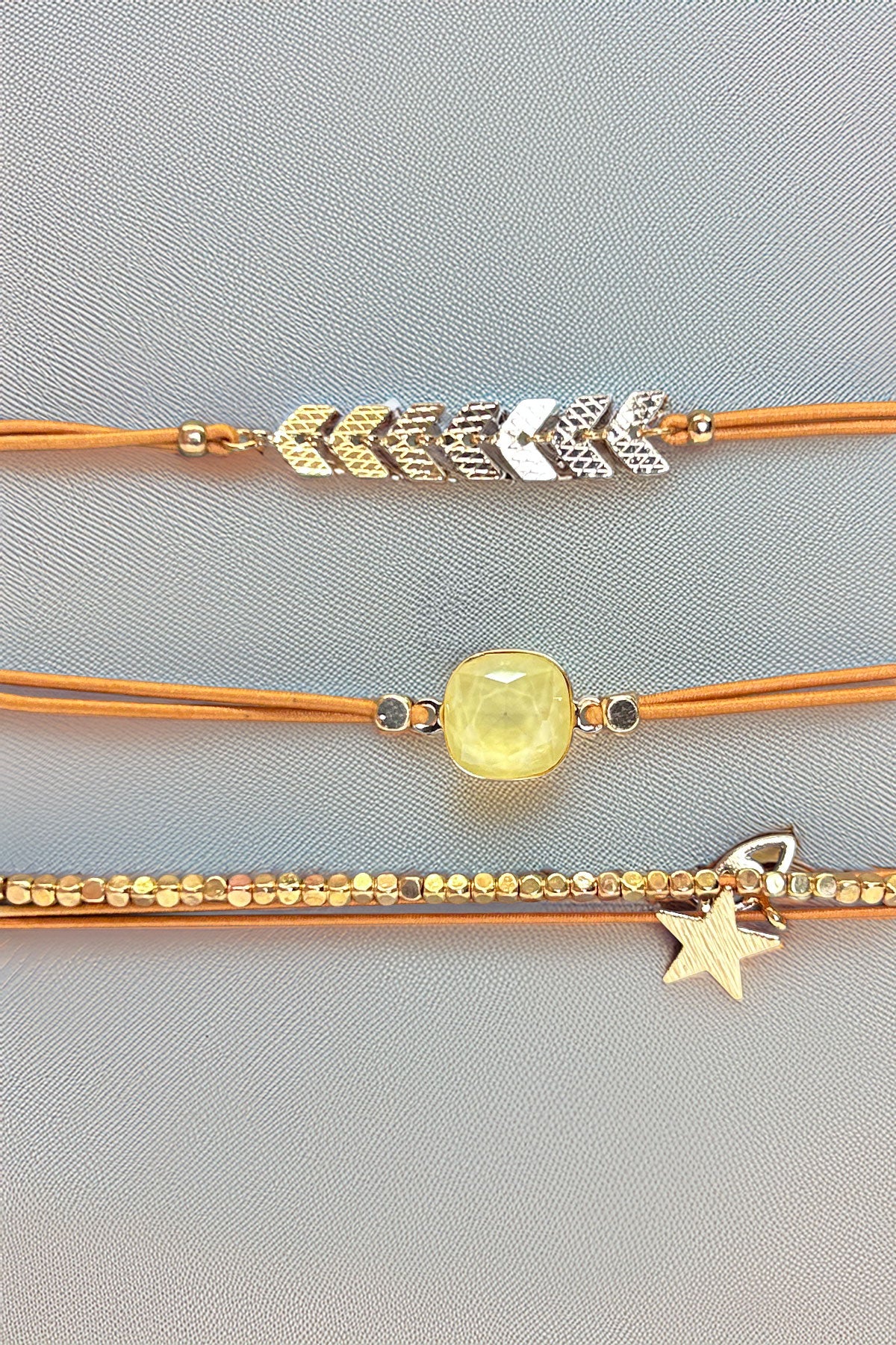 Front view of gold-tone triple bracelet set with star charm