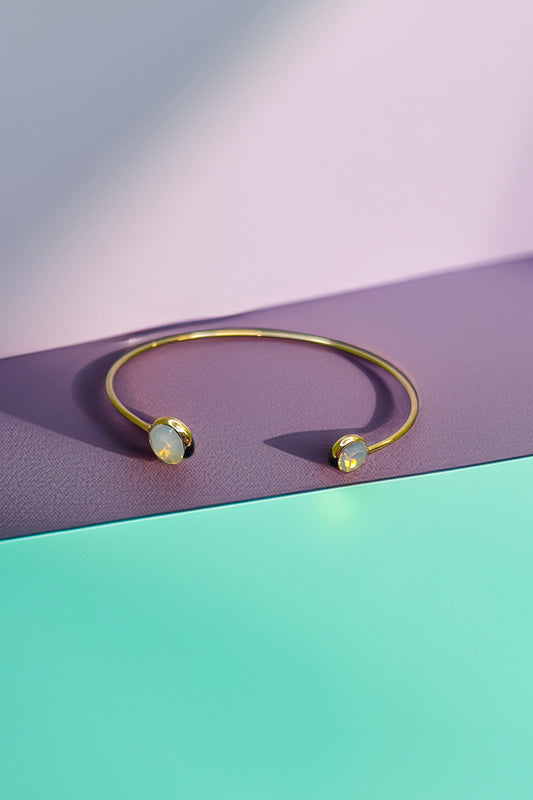 Opal gold cuff bracelet on a purple background