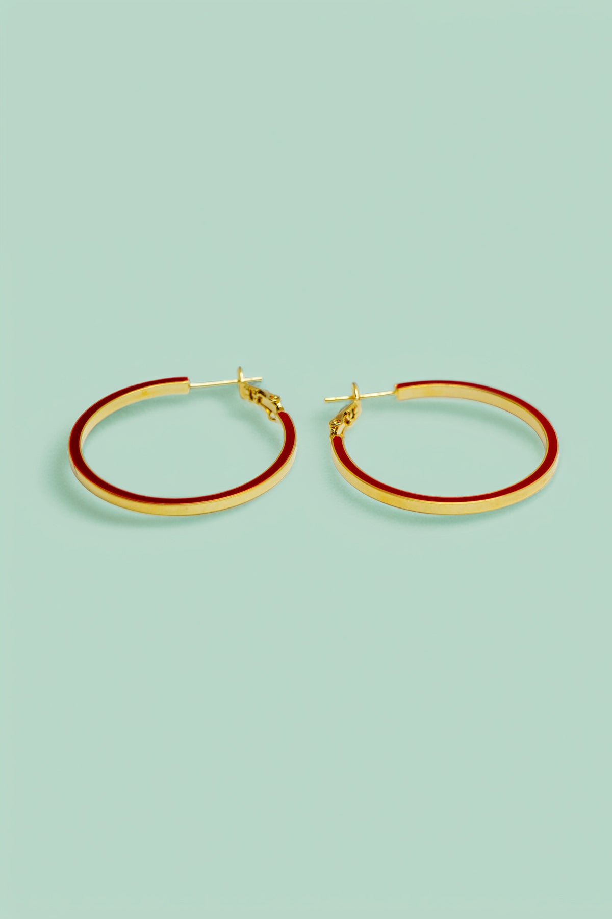 Main view of gold-tone hoop earrings with red accents