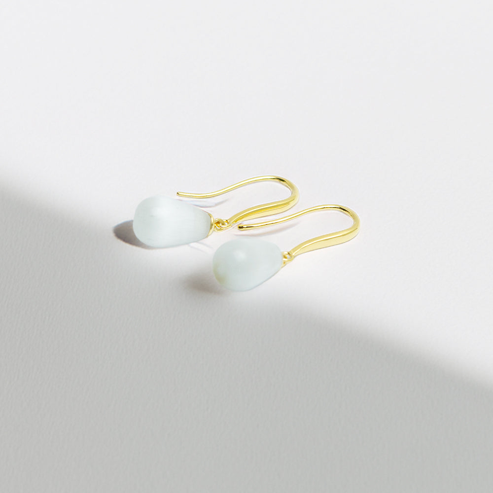 Side angle view of gold and pearl teardrop earrings