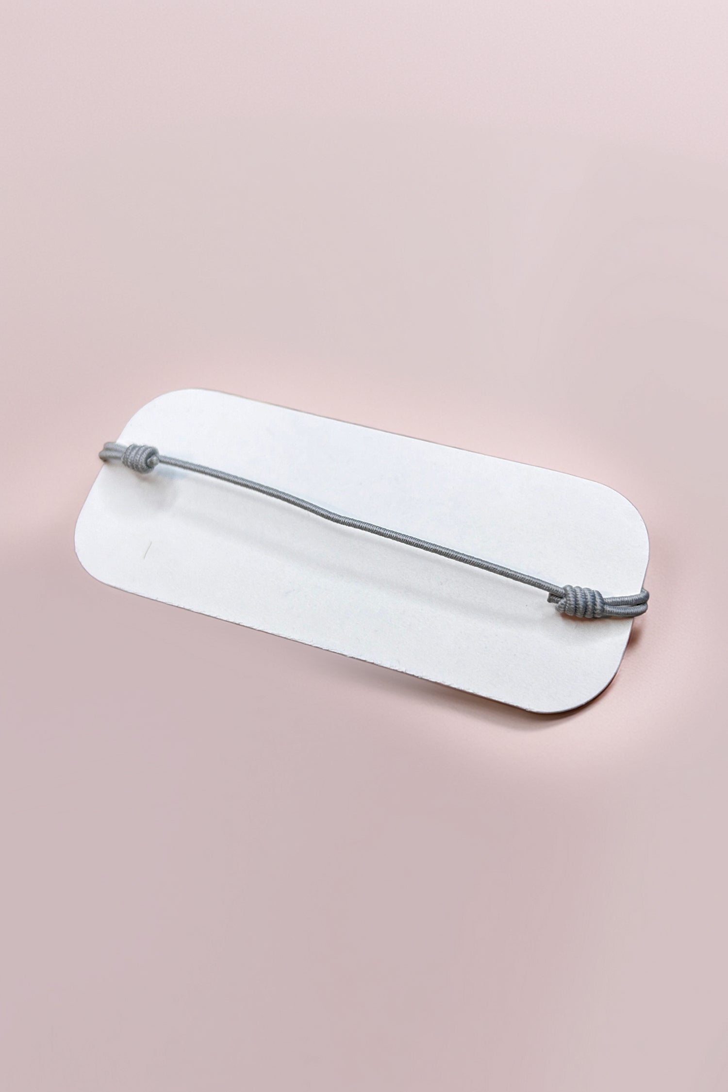 Back view of adjustable rose quartz bracelet on display card