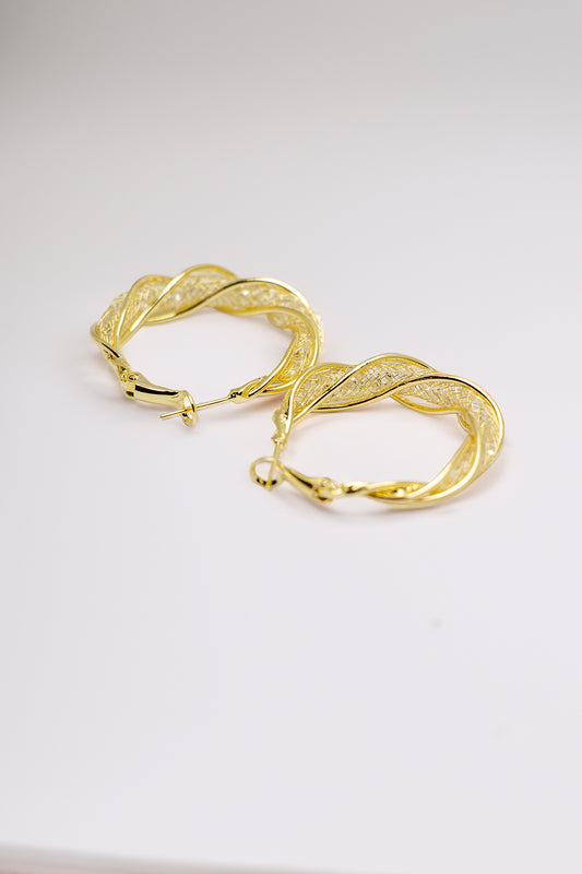 Close-up of intricate twisted pattern hoop earrings