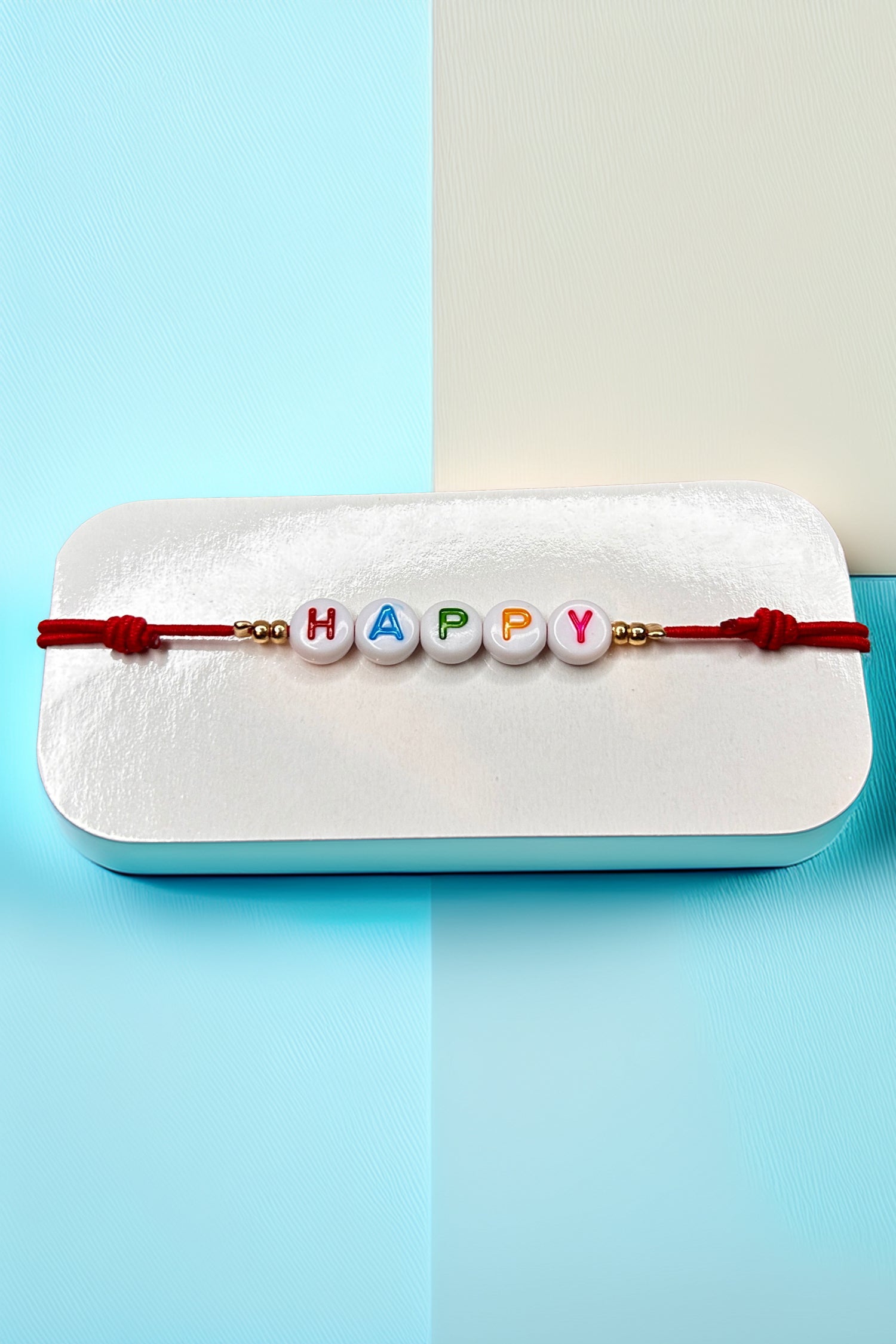 Front view of the 'Happy' bracelet with red cord