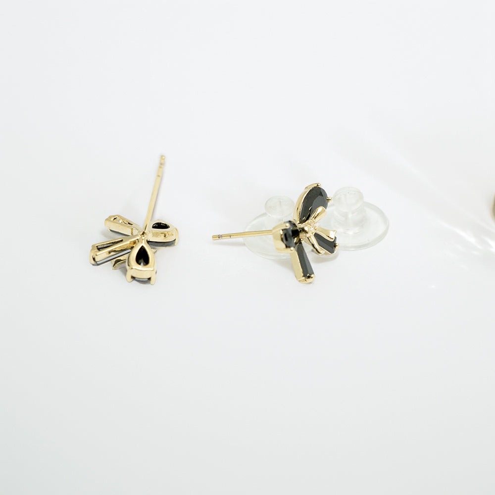 Back view of black bow earrings with gold posts and clear backings