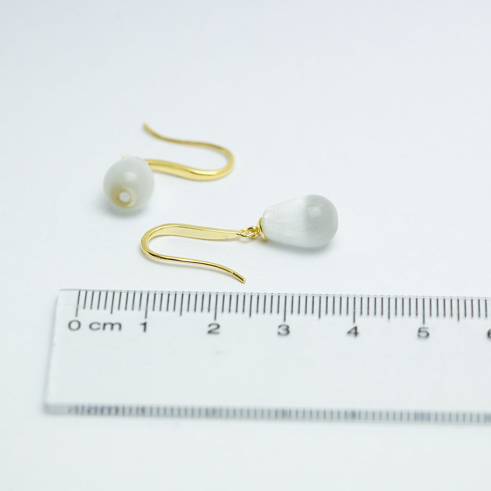 Gold and pearl teardrop earrings with ruler for scale