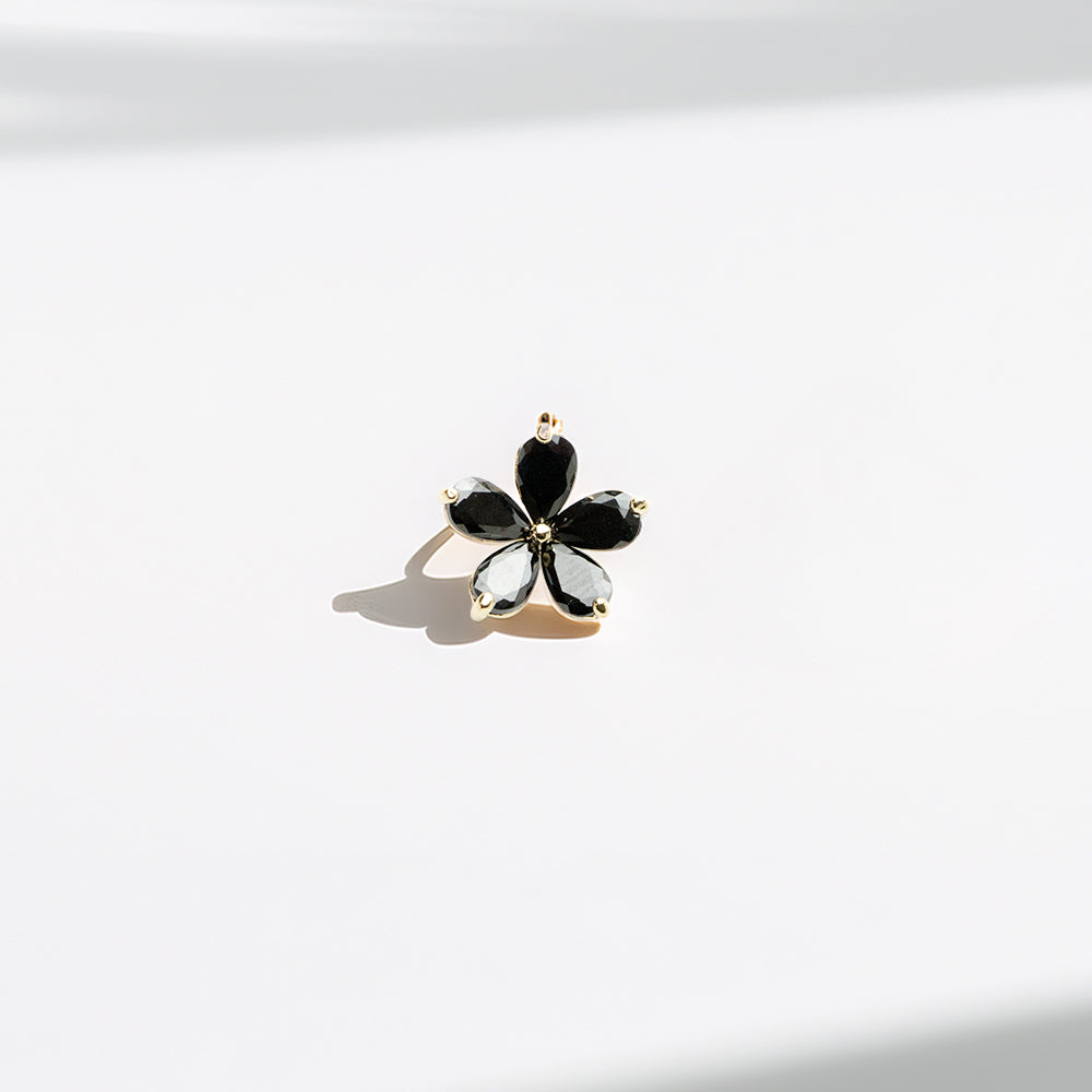 Single black floral stud earring with gold trim