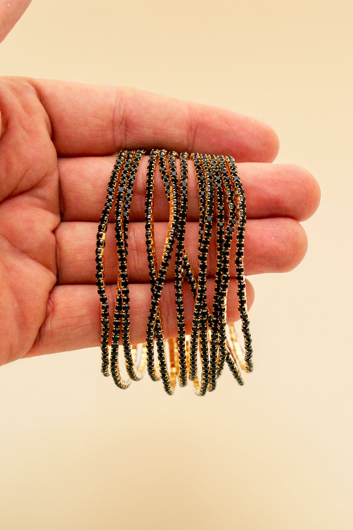 Hand holding multiple rhinestone bracelets