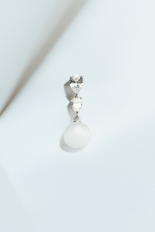 Single earring on a soft white drape