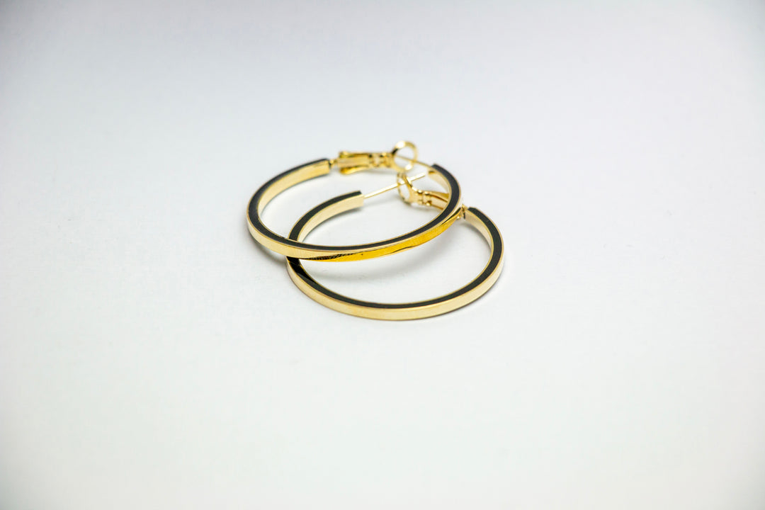 Angled view of overlapping gold hoop earrings