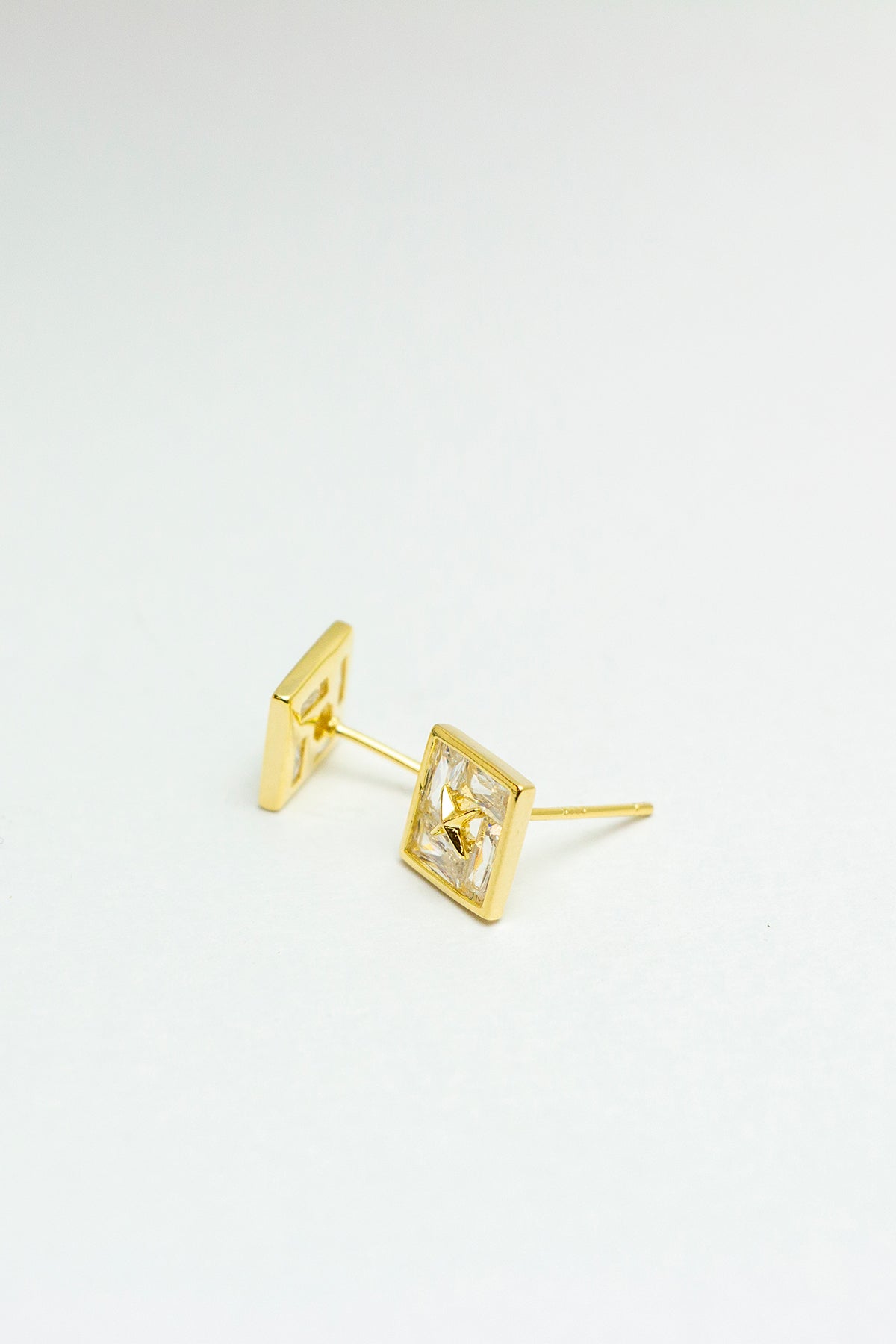 Side angle of gold-tone stud earrings