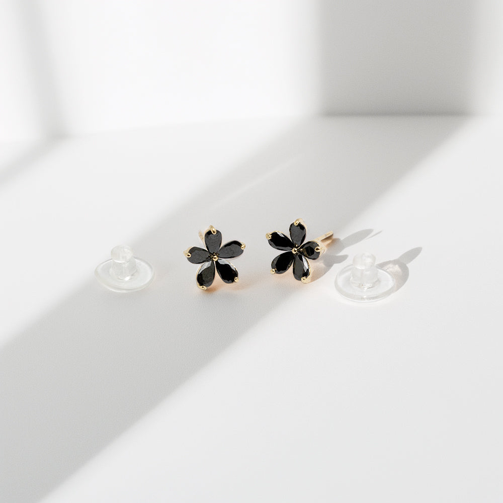 Black stud earrings in natural lighting for detail view