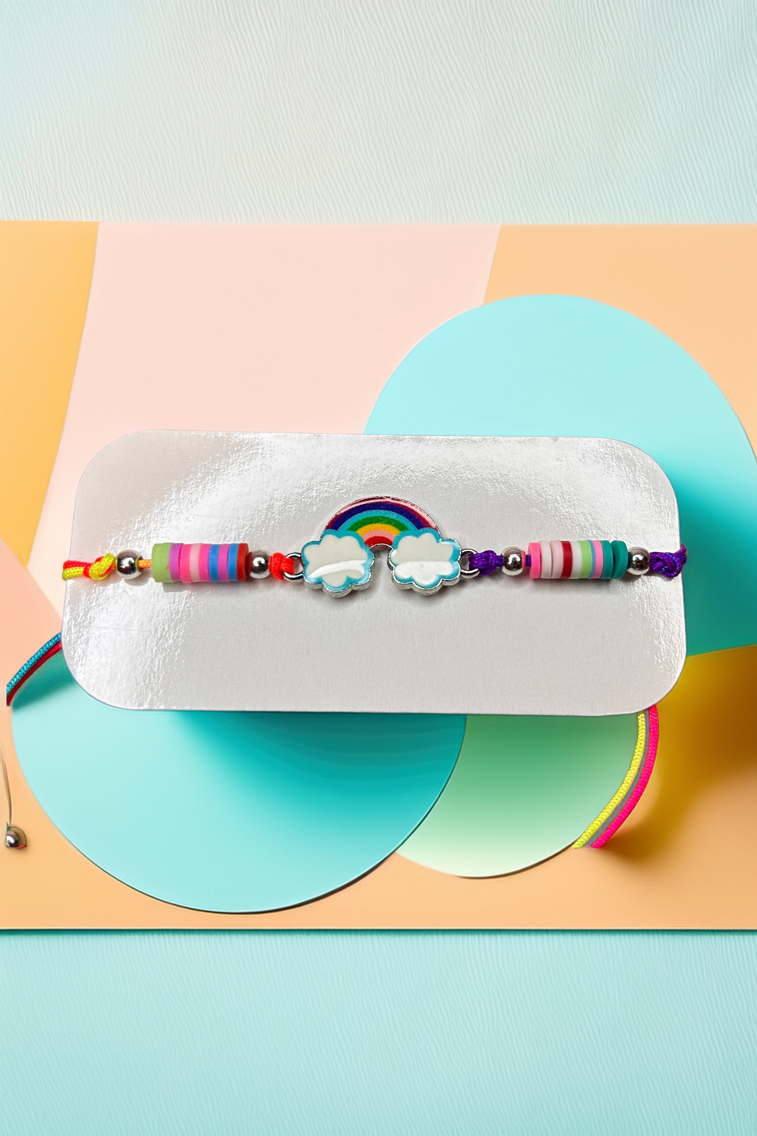 Close-up of rainbow charm and beads on bracelet