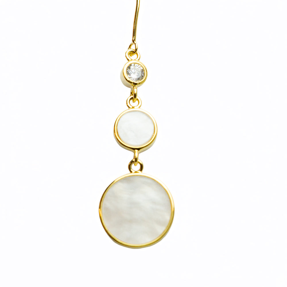Isolated view of gold drop earrings with mother of pearl