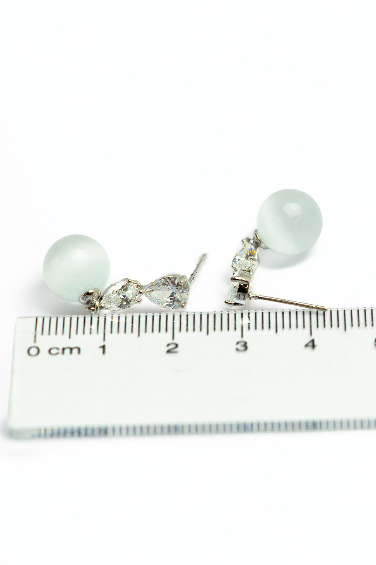 Pearl and crystal earrings with measurement scale
